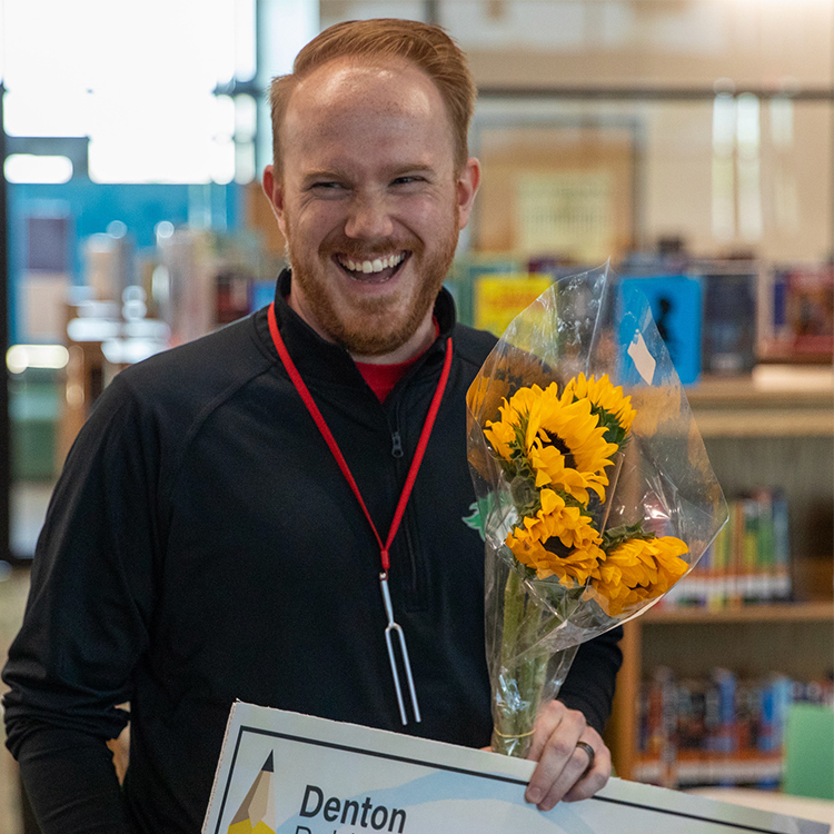 Dillon Downey holding a check with Staff 